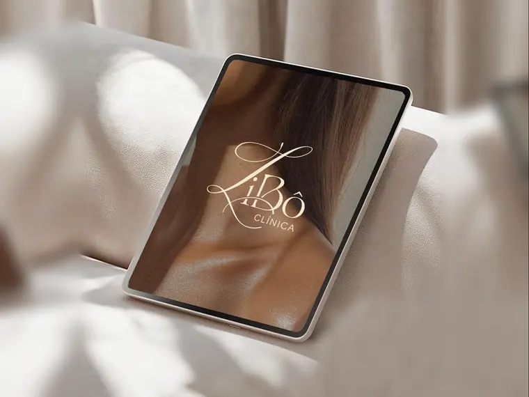 Tablet apoiado em um sofá claro exibindo o logotipo da LiBô Clínica