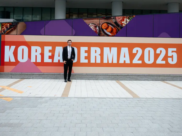 Participante da Sigma em frente ao painel do KoreaDerma 2025, na Coreia do Sul