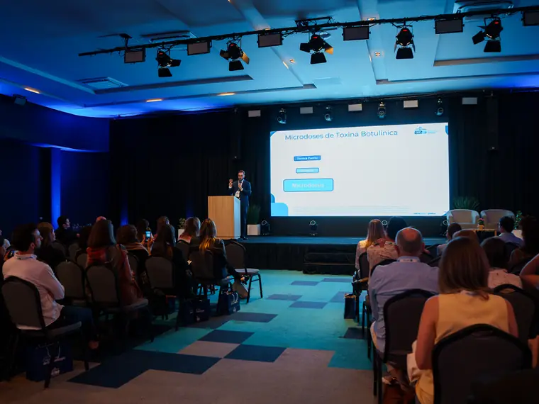 Palestra sobre microdoses de toxina botulínica em auditório cheio, em evento da SBD-SC
